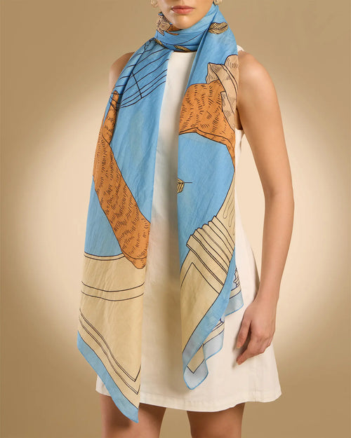 Woman model wearing Illustrated light blue rectangle scarf with classical design featuring a cat, parrots and pillars 