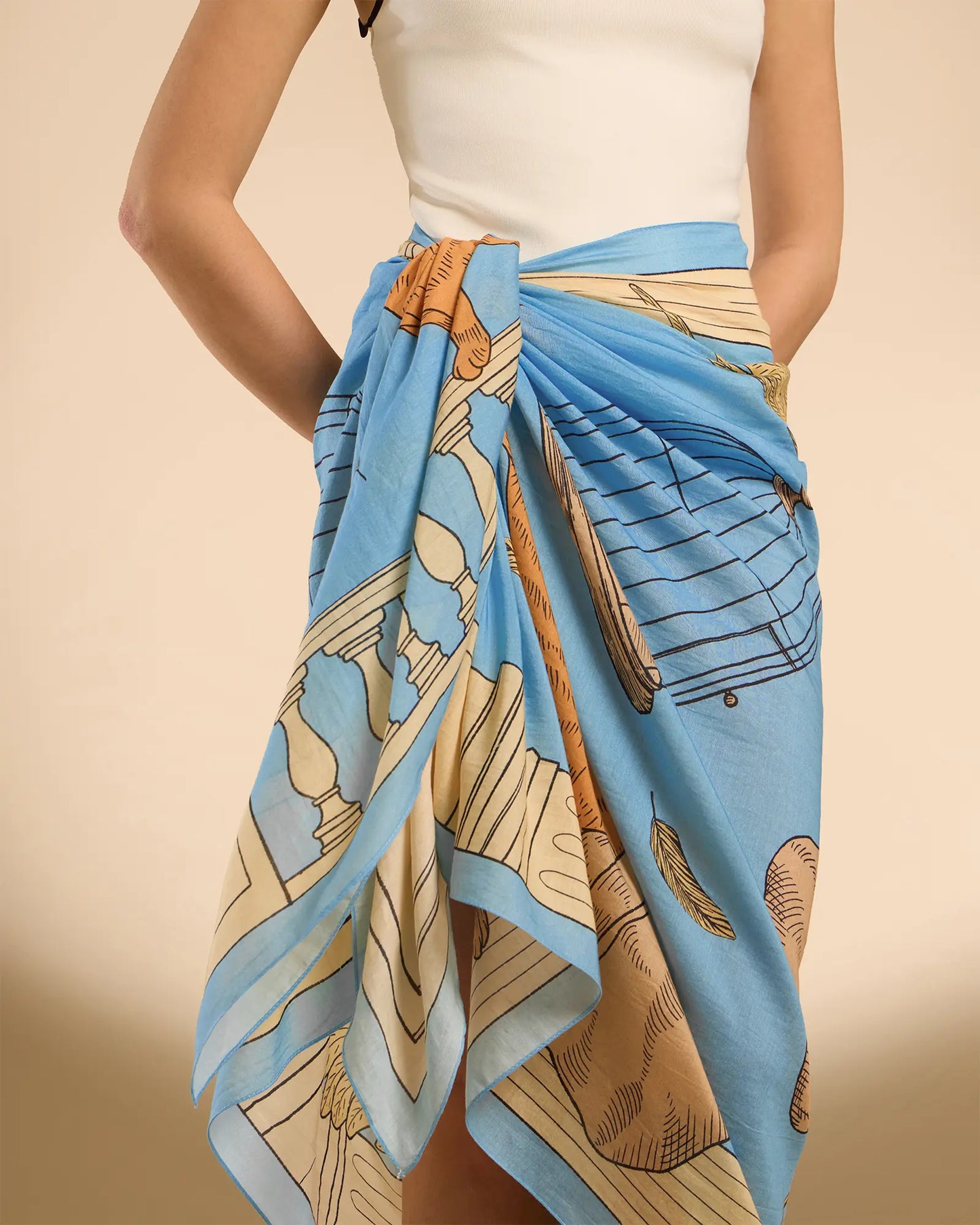 Woman model wearing Illustrated light blue rectangle scarf as a pareo/sarong